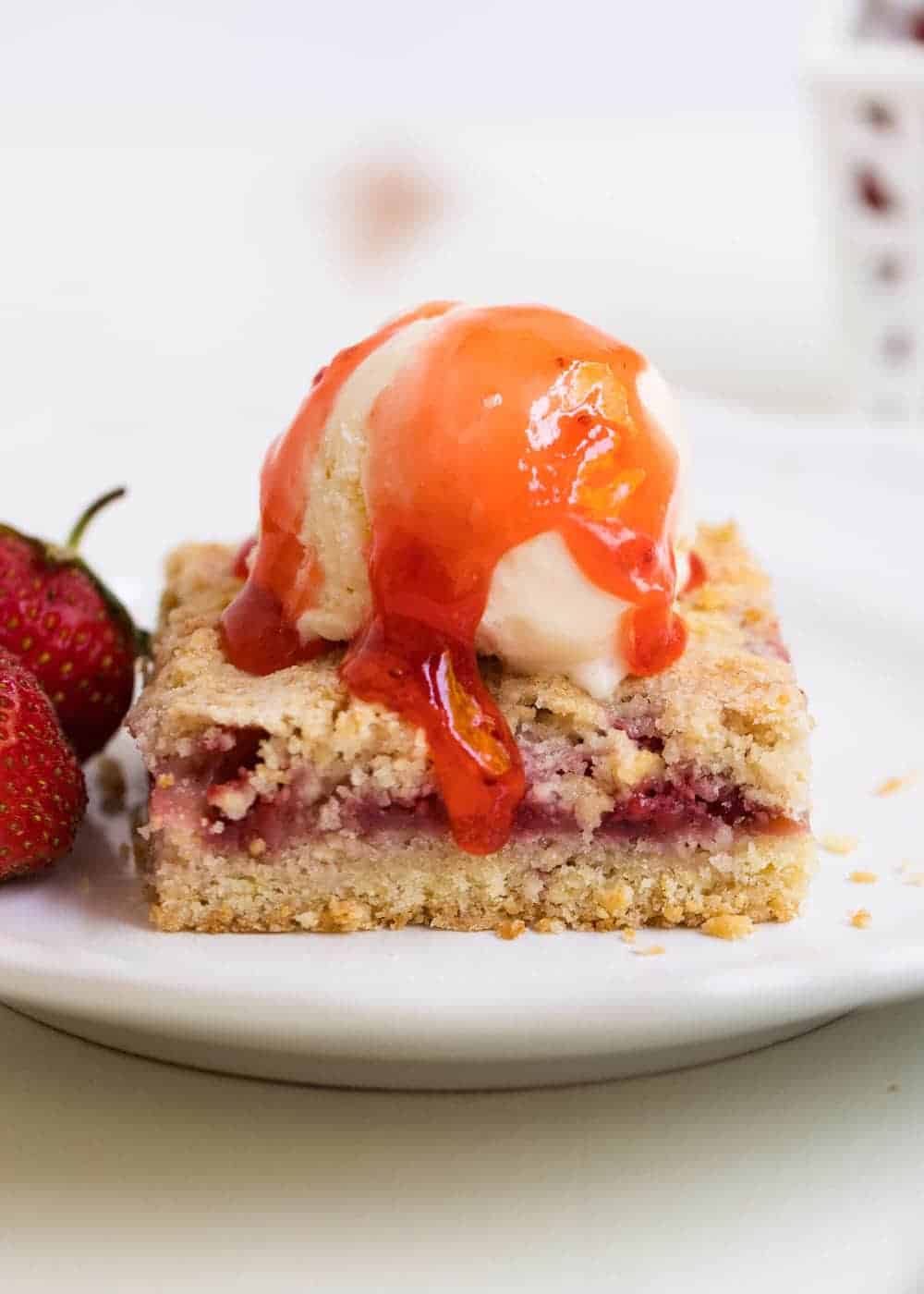 Strawberry bars with ice cream and strawberry jam on top.