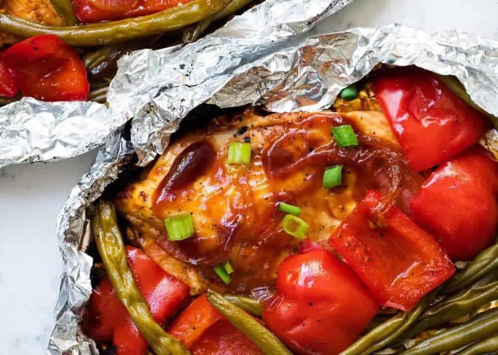 Grilled bbq chicken in a foil pack with veggies.