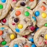 Stack of M&M cookies on plate.