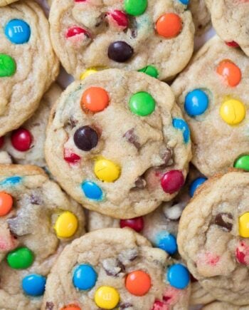 Stack of M&M cookies on plate.