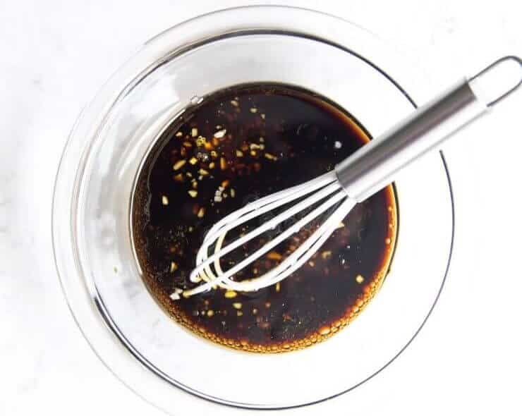 Whisking together steak marinade in a bowl.
