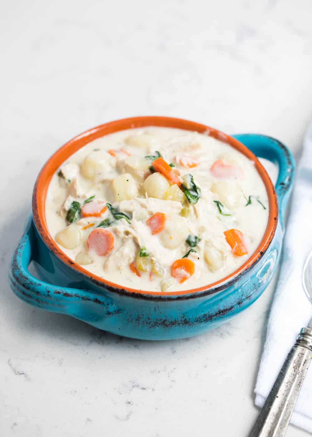 chicken gnocchi soup in a blue bowl 