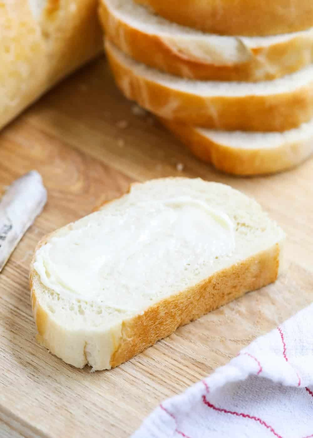 slice of french bread with butter spread on top 
