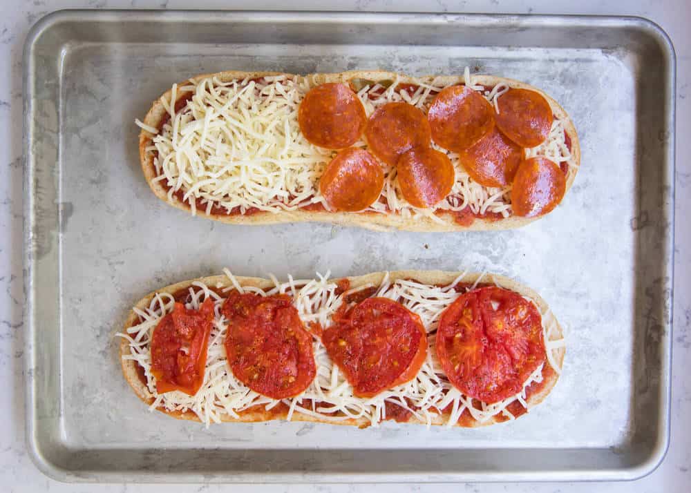 Pizza bread on a baking sheet with toppings.