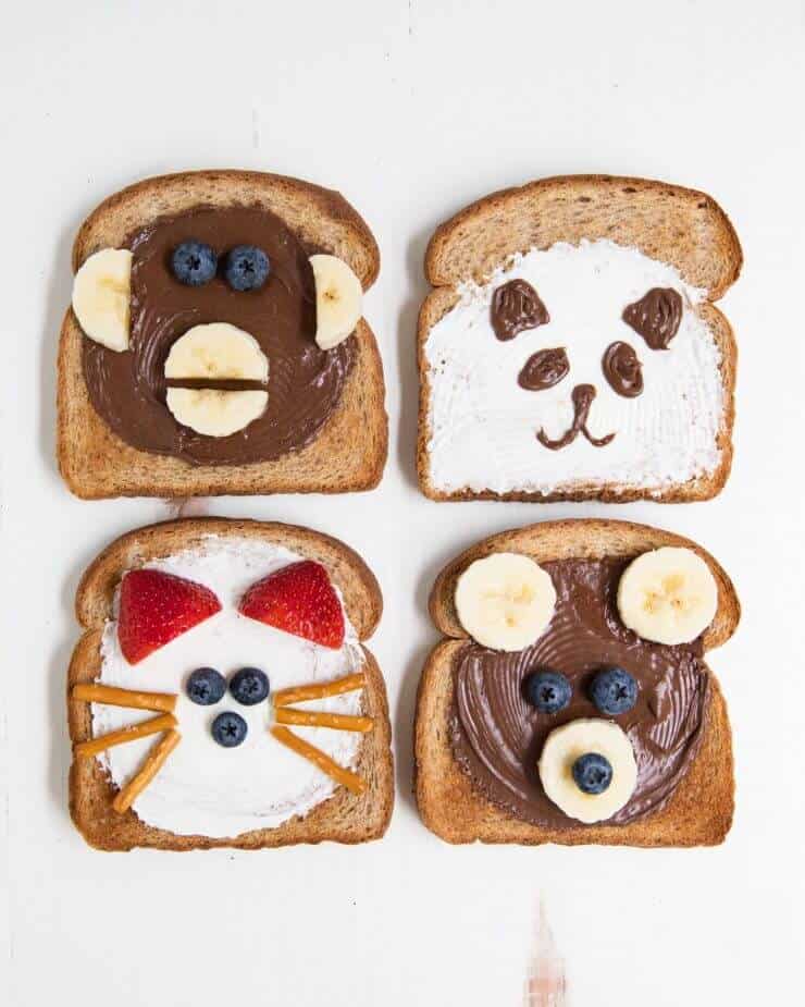 4 pieces of toast decorated to look like animal faces 