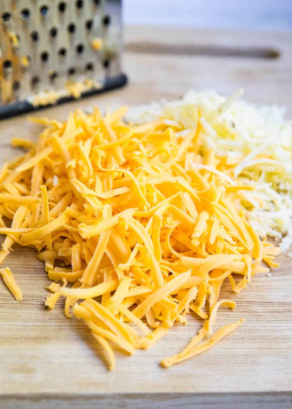 Grated cheese on cutting board.