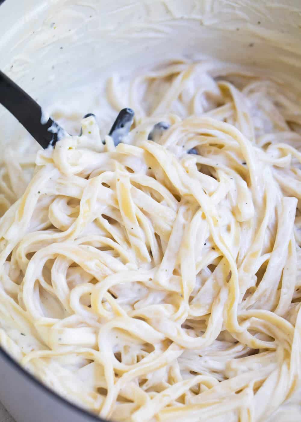 pasta fork scooping cream cheese alfredo 
