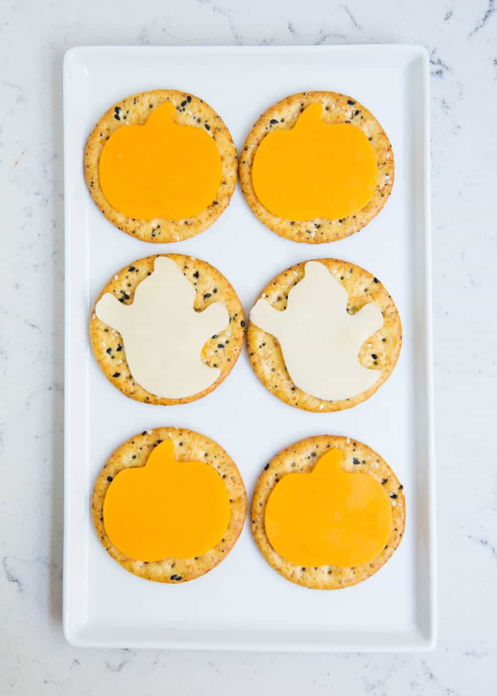 Crackers with cheese slices cut out to look like pumpkins and ghosts.