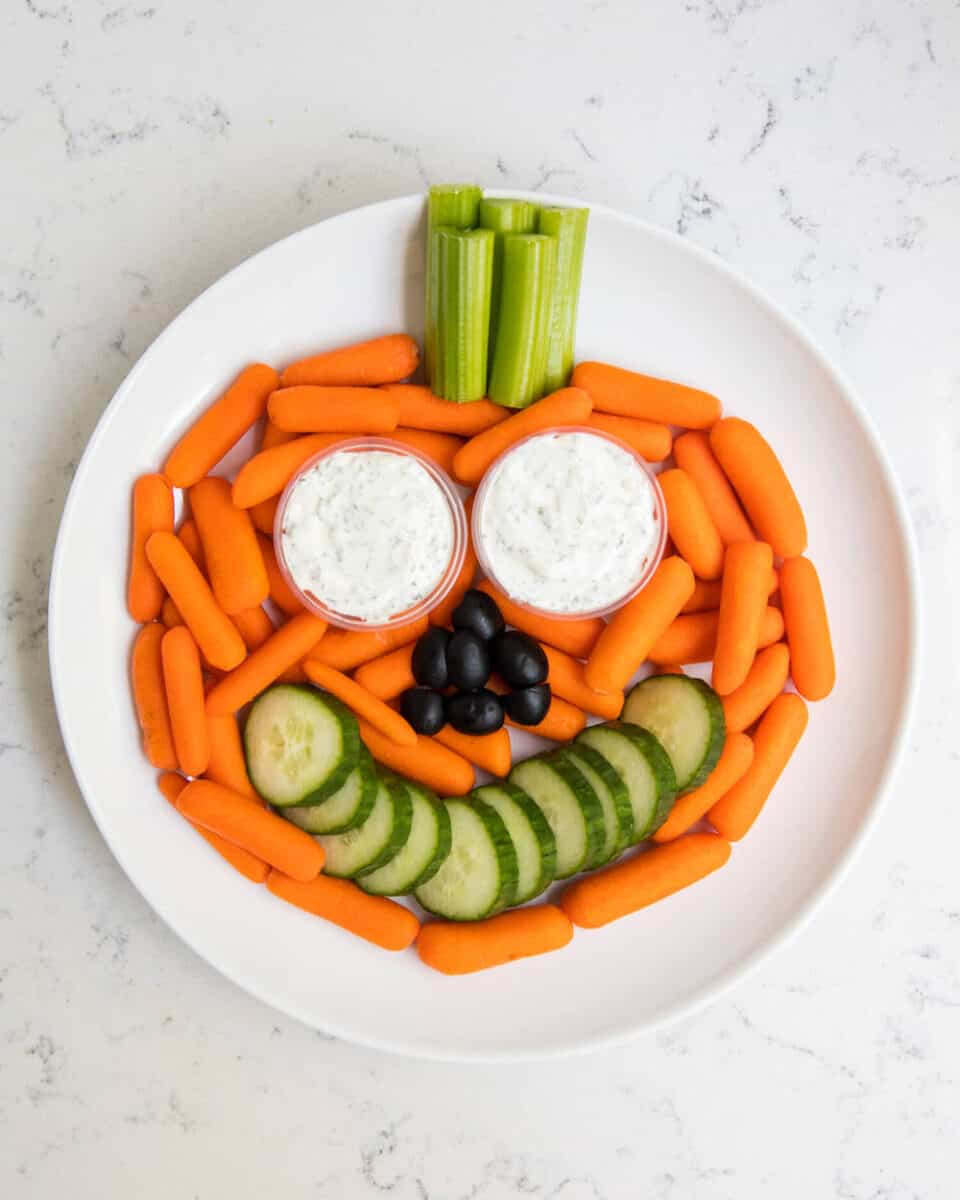 plate of veggies and dip in the shape of a pumpkin 