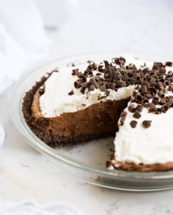 chocolate silk pie in a pie pan with a slice taken out