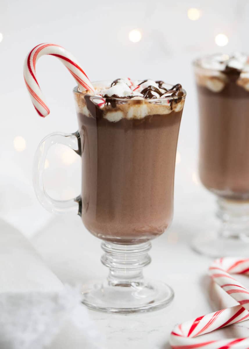 A rich and creamy homemade hot chocolate that tastes heavenly on a cold winter day. Only takes 5 ingredients and 10 minutes to make! homemade hot chocolate in glass mug with candy cane