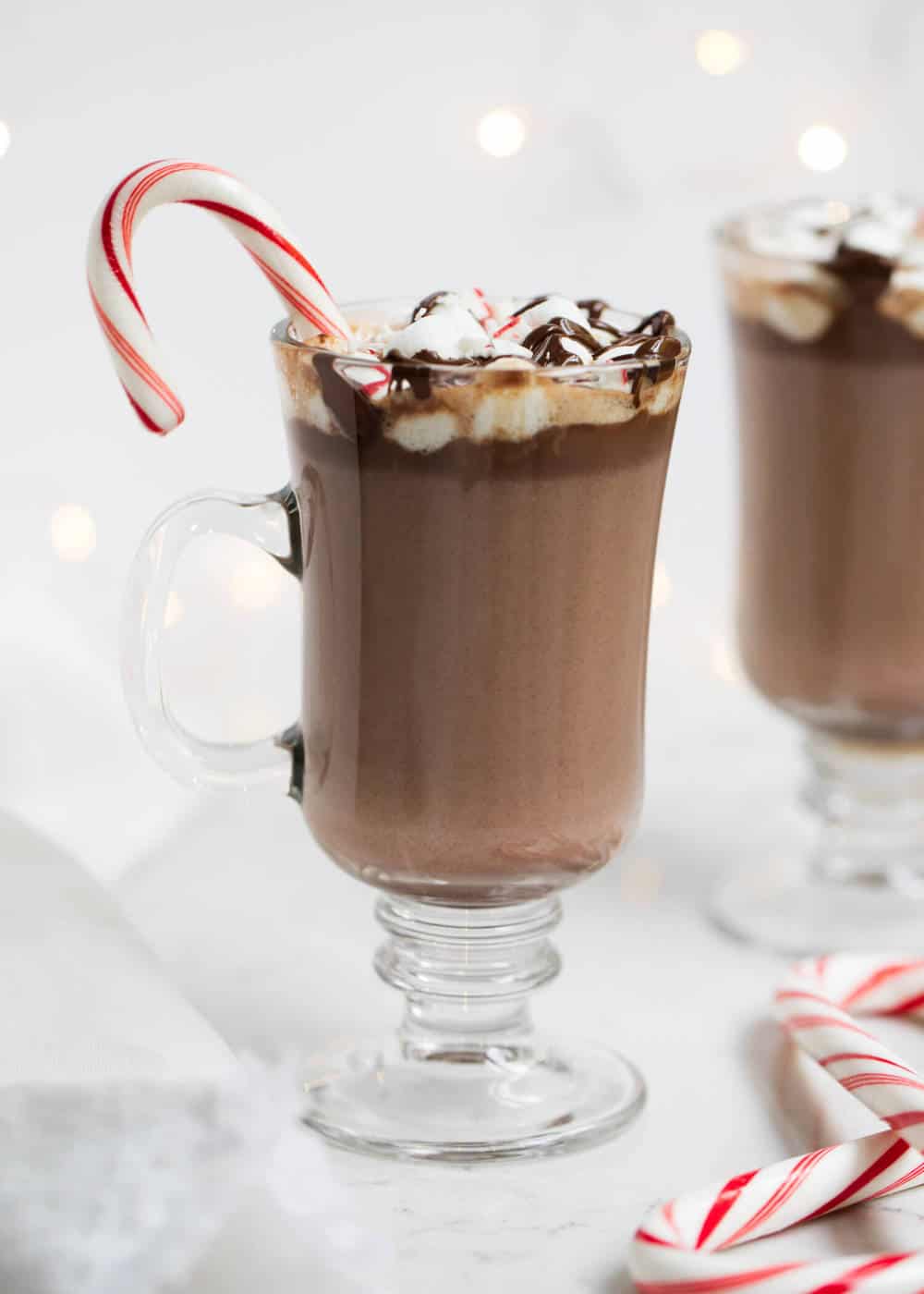 Hot chocolate in a glass cup with candy canes. 