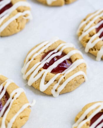 peanut butter and jelly thumbprint cookie drizzled with vanilla glaze
