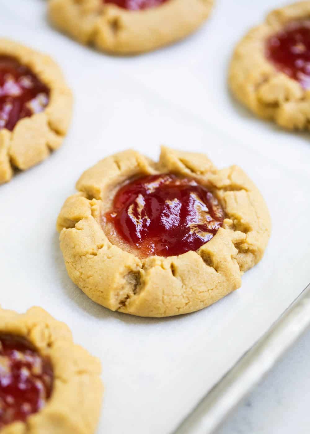 Peanut butter and jelly cookies on baking sheet.