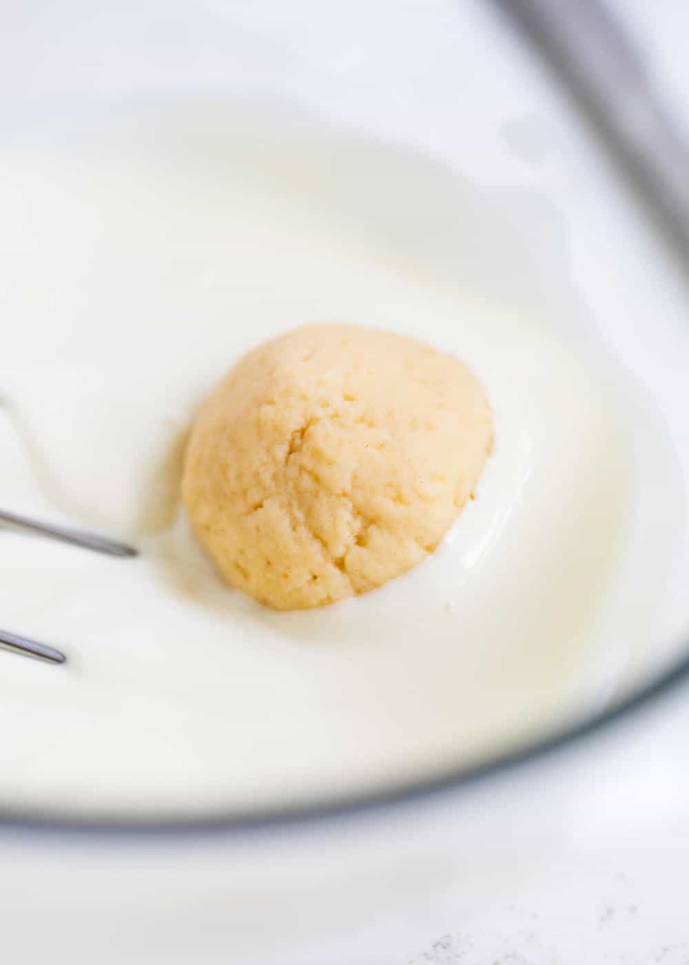 Dipping sugar cookie truffle in white chocolate.