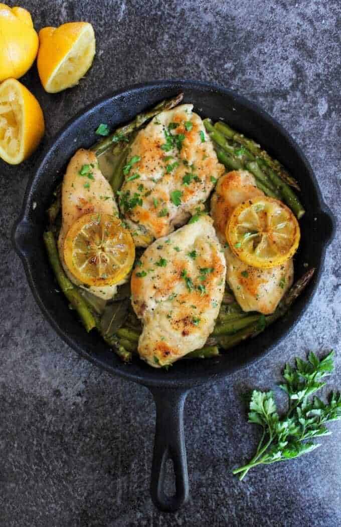 lemon chicken and asparagus in a cast iron skillet 