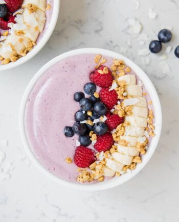 smoothie bowl topped with fresh fruit and granola