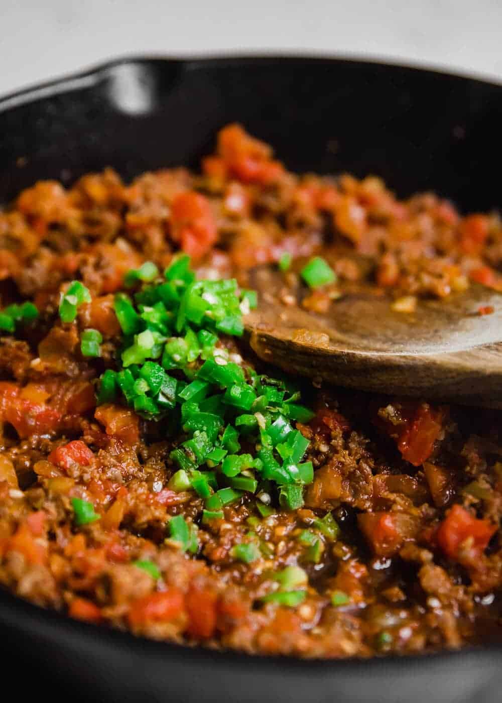 Cooking chorizo and diced jalapeno in a cast iron skillet.