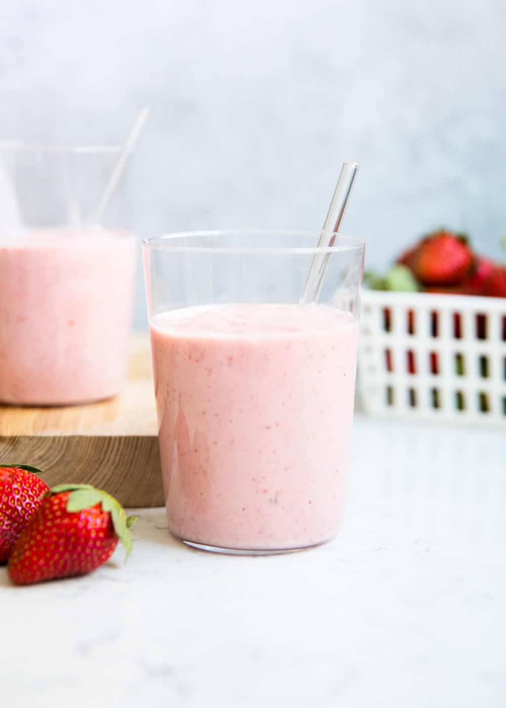 Strawberry banana smoothie in a glass with a straw.