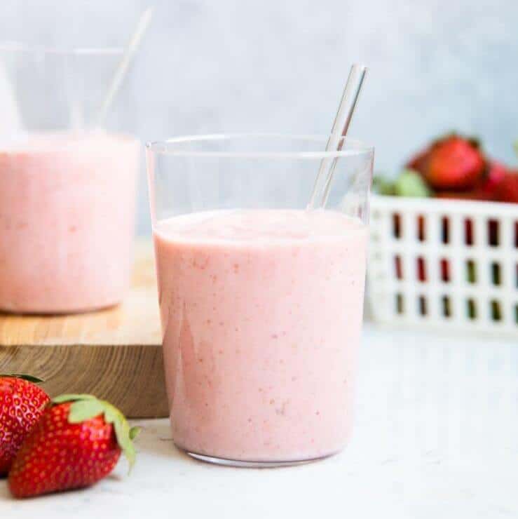 Strawberry banana smoothie in glass with straw.