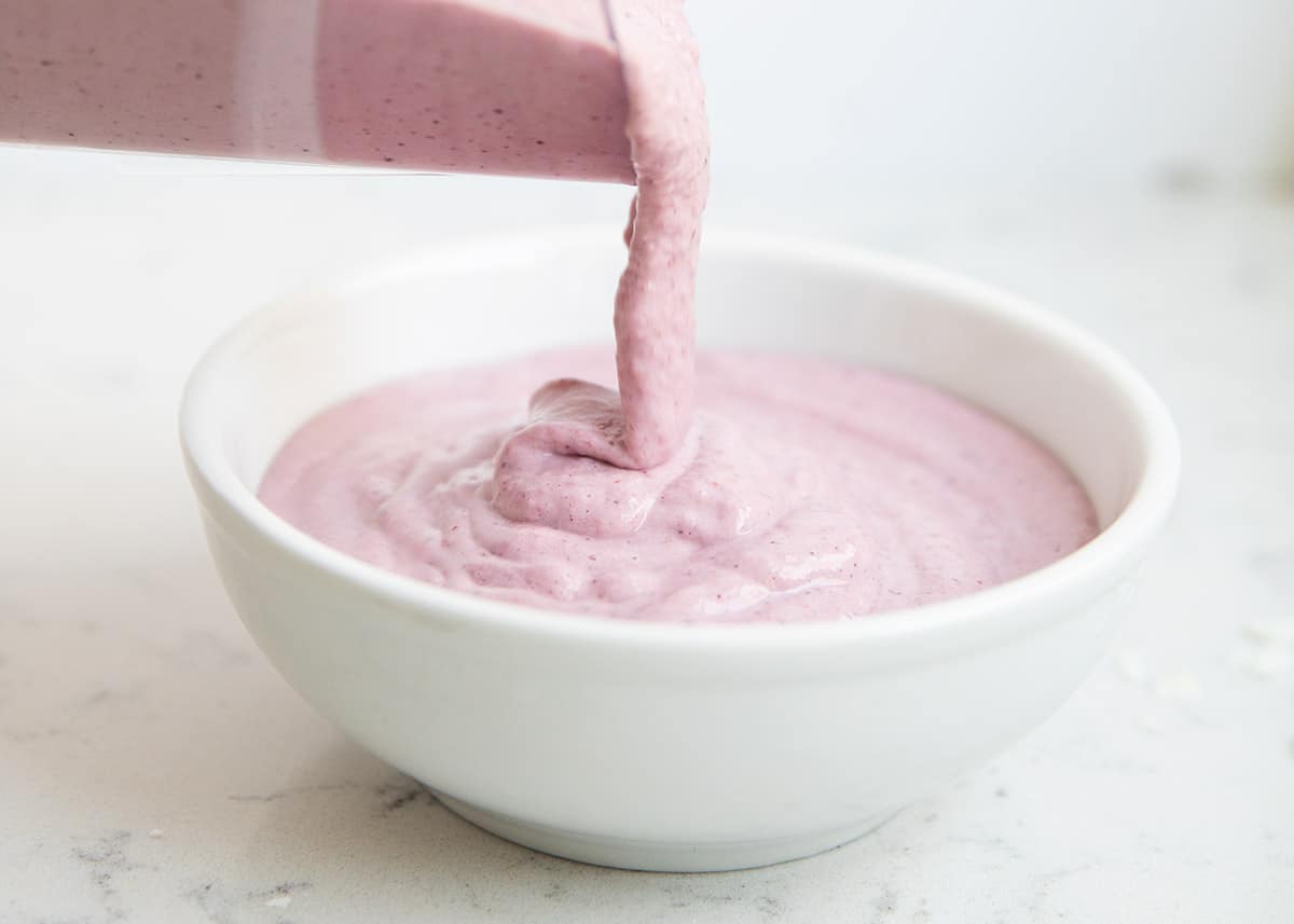 Pouring the smoothie into a bowl.