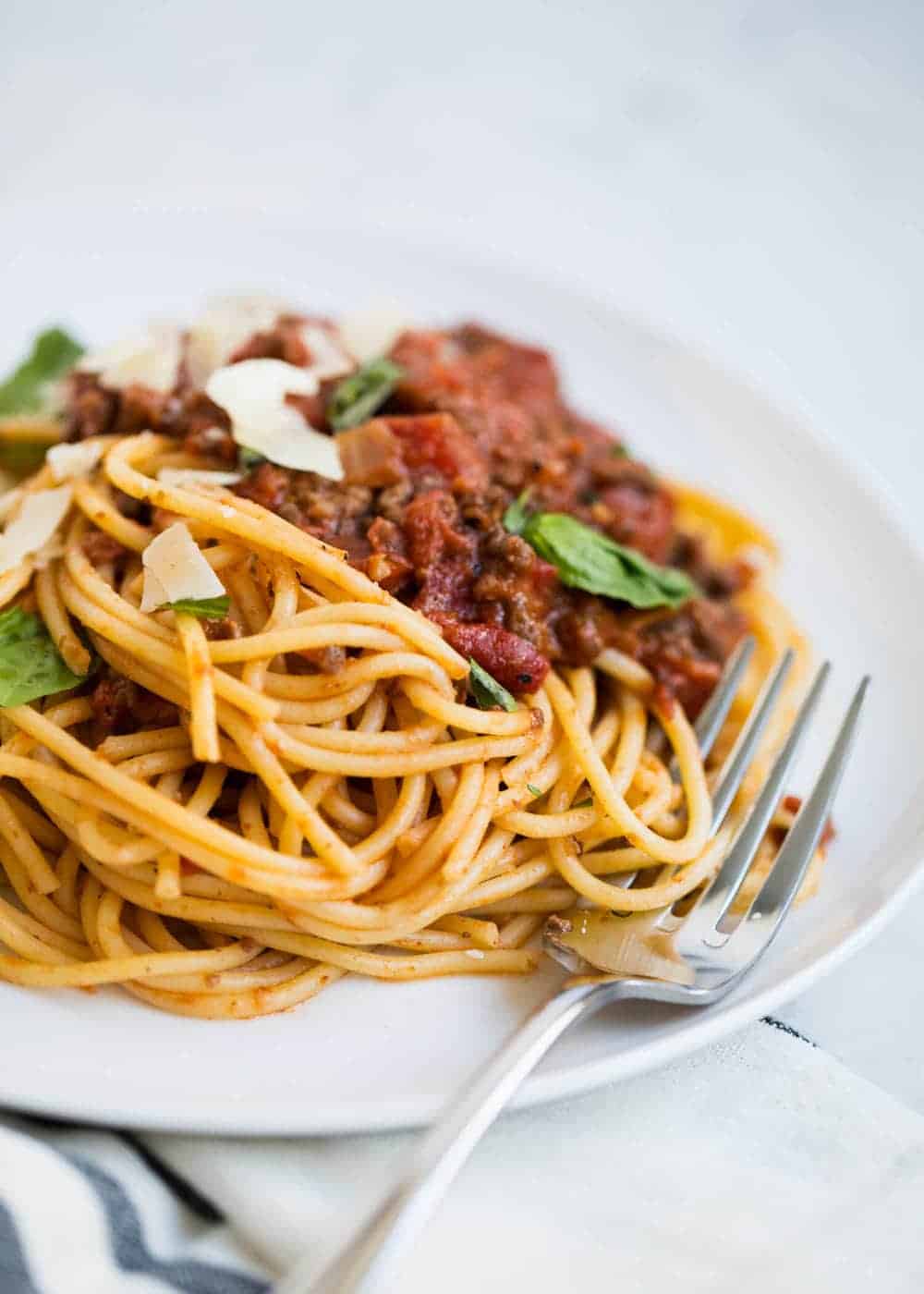 Spaghetti bolognese on plate with fork.