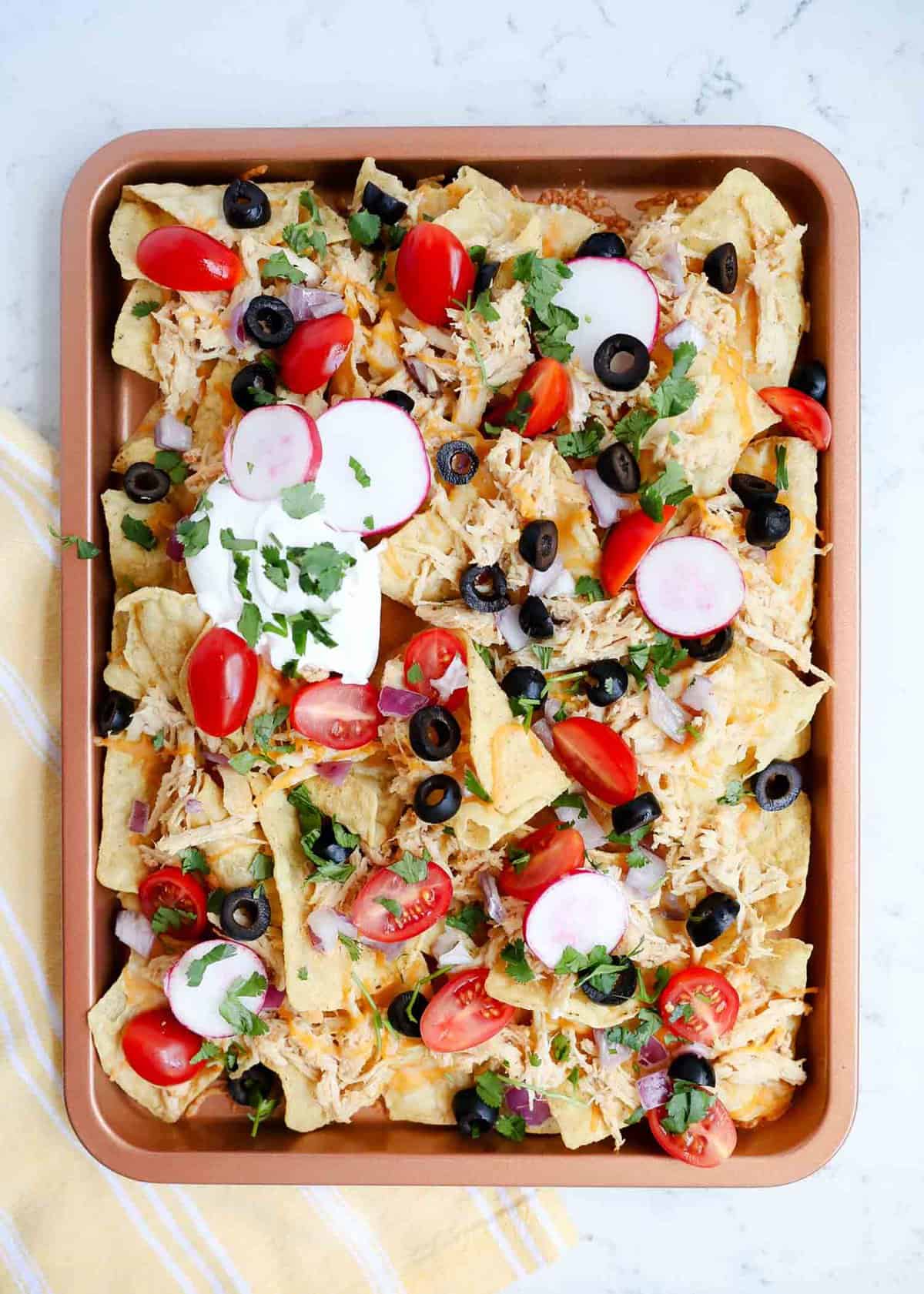 Sheet pan nachos with shredded chicken.