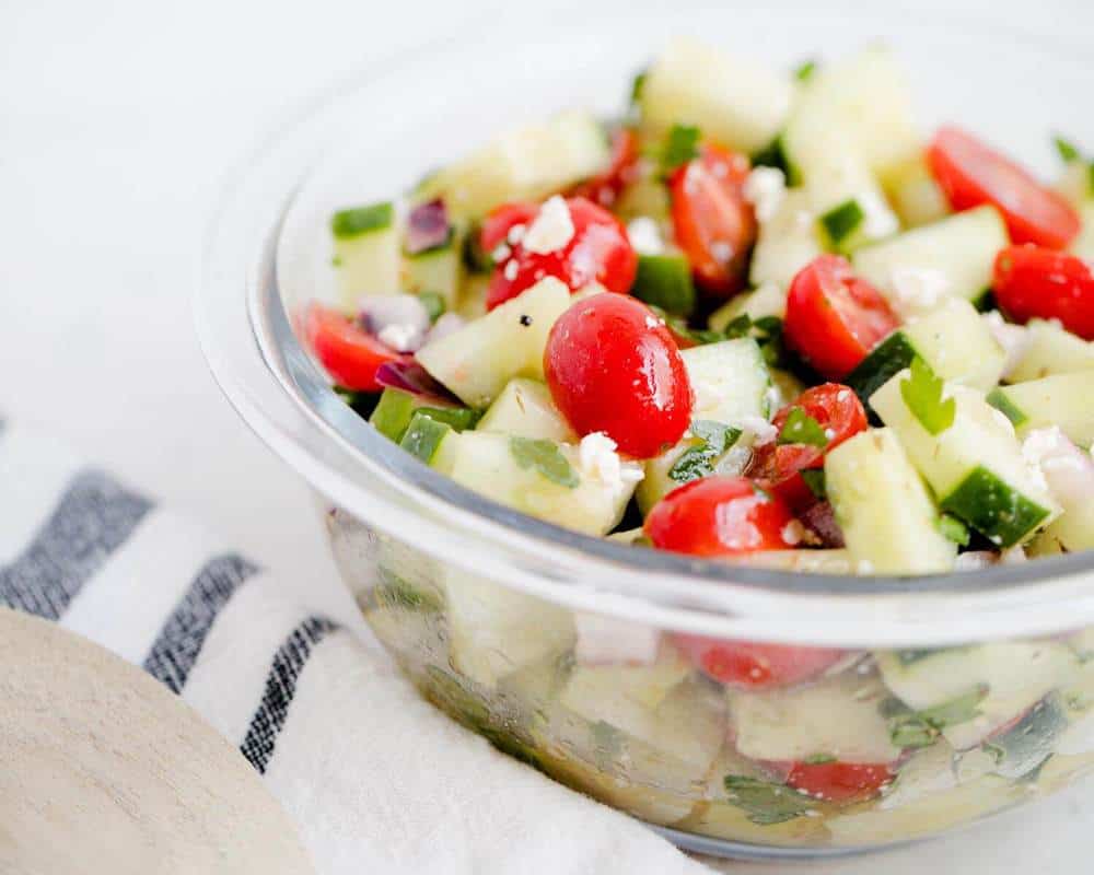 Cucumber tomato salad in a glass bowl.