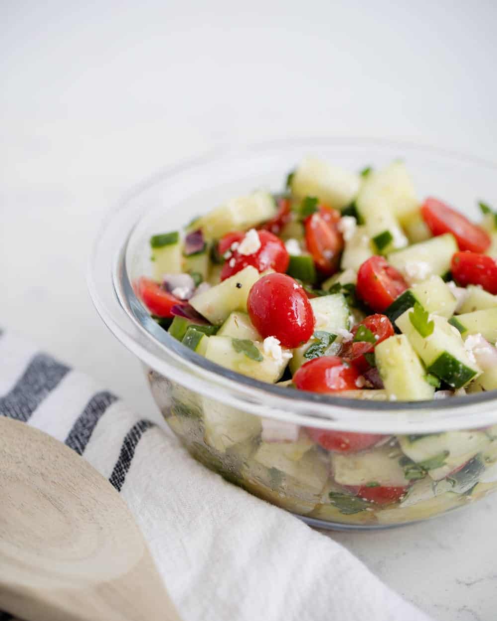 Cucumber tomato salad in a glass bowl.