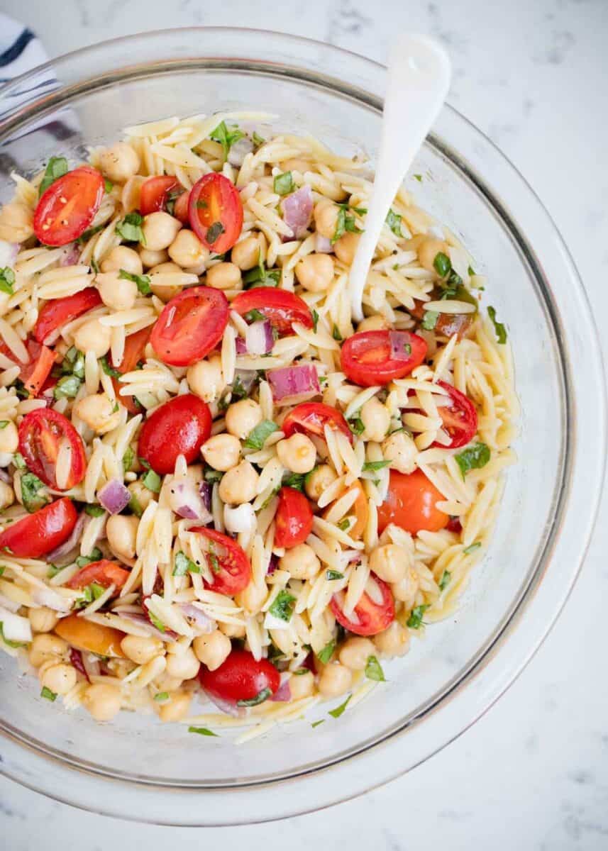 orzo pasta salad in a bowl with a spoon 