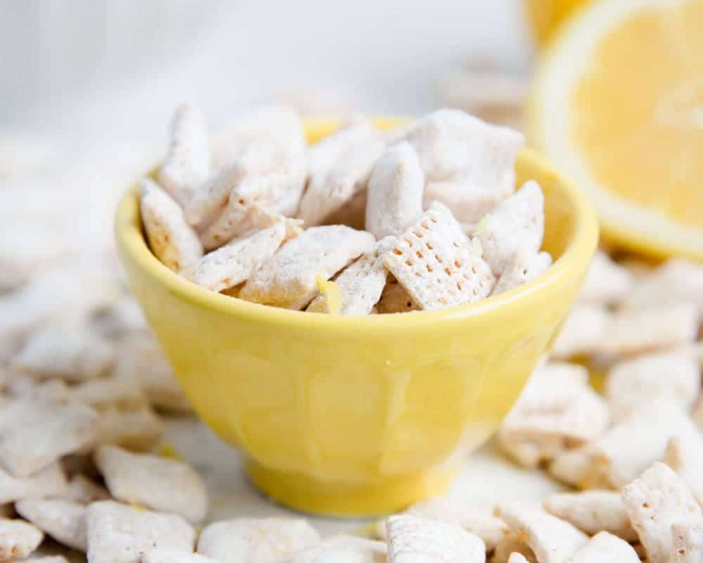 Lemon muddy buddies in a yellow bowl.