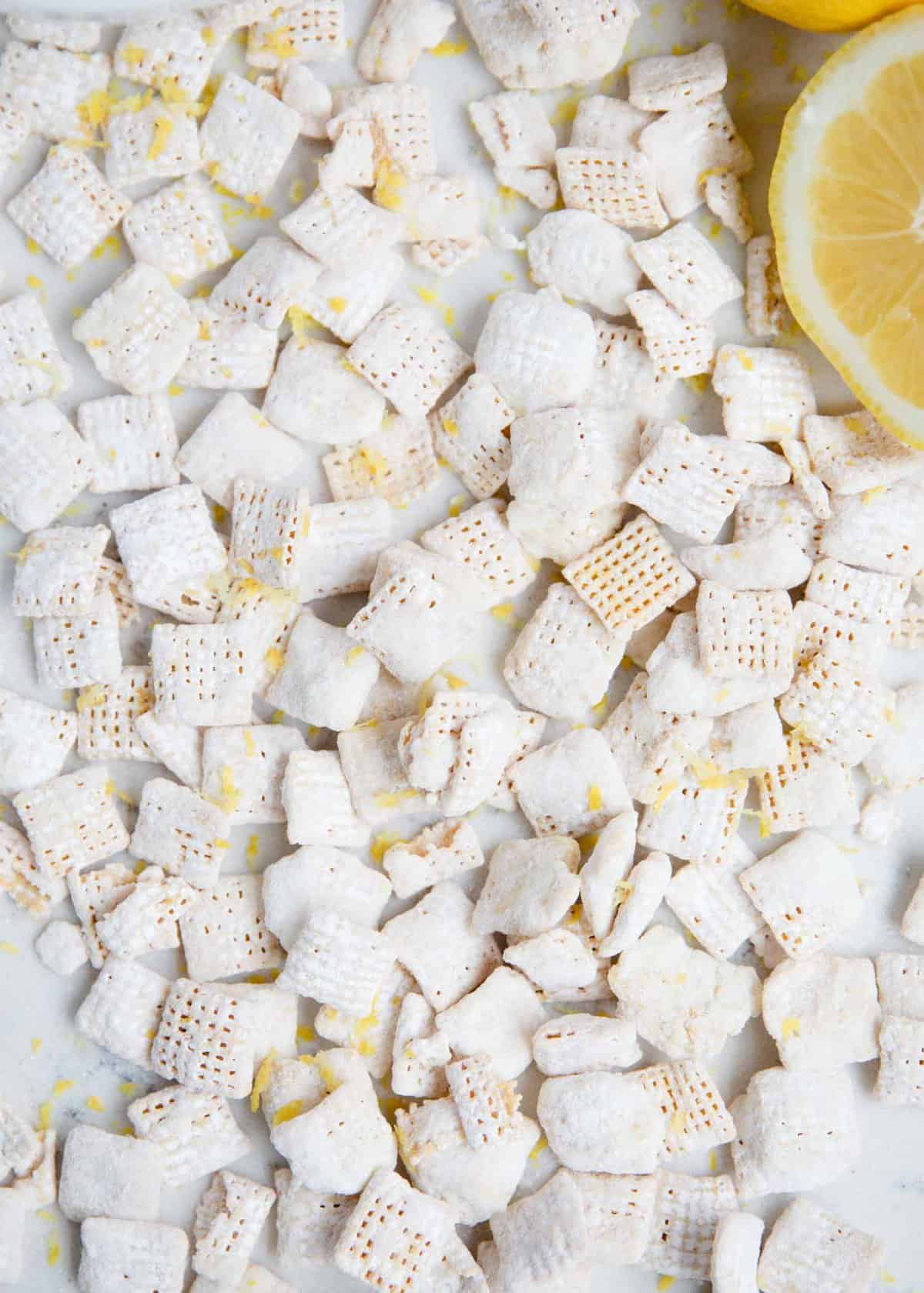 Lemon muddy buddies with fresh lemon zest on top.