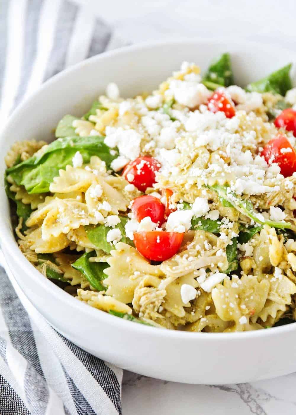 Chicken pesto pasta salad in a white bowl.