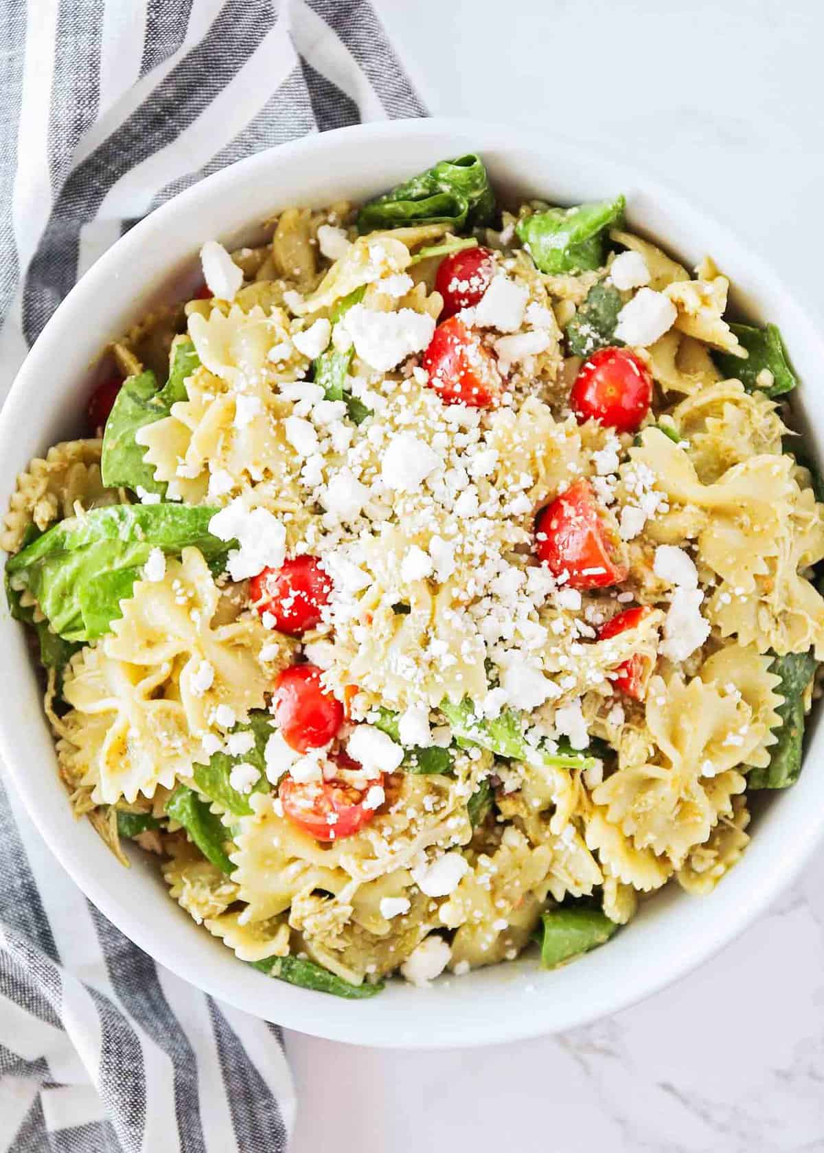 Pesto chicken pasta salad in a large bowl.