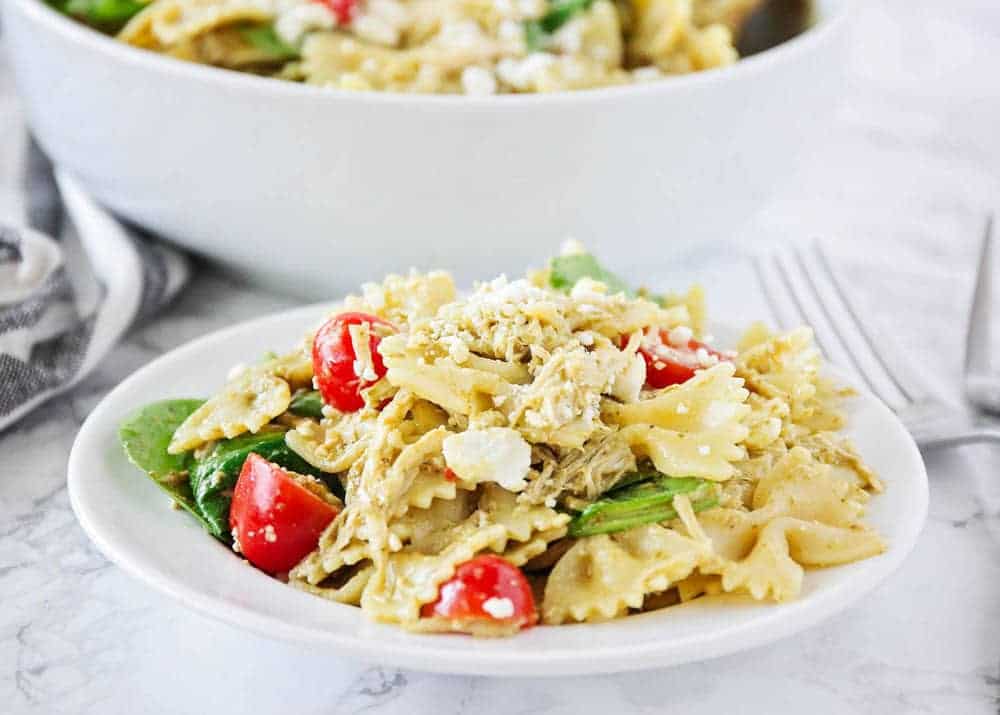 Chicken pesto pasta salad on a white plate.