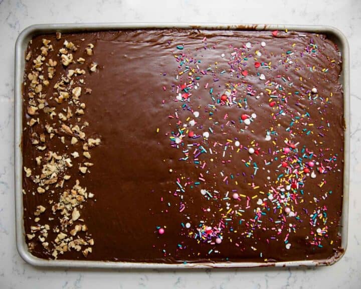 Texas sheet cake topped with nuts on one half and sprinkles on the other 