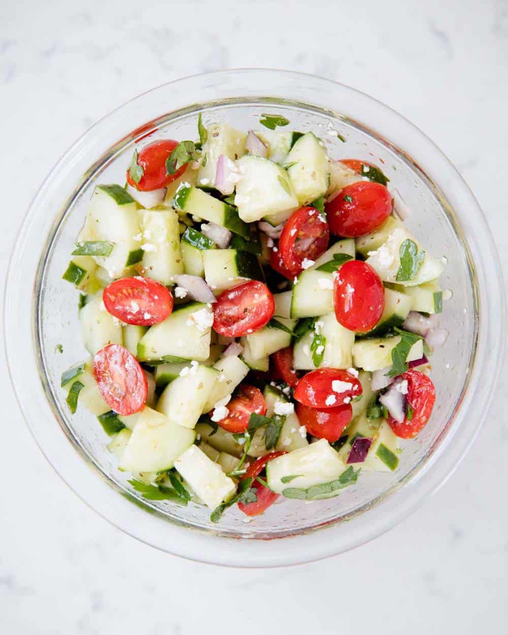 Tomato and cucumber salad in a glass bowl.