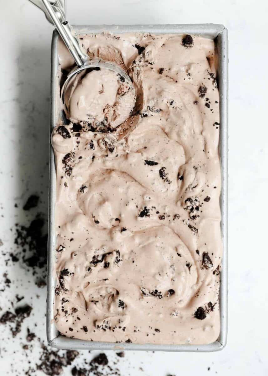 scooping chocolate ice cream out of a loaf pan 