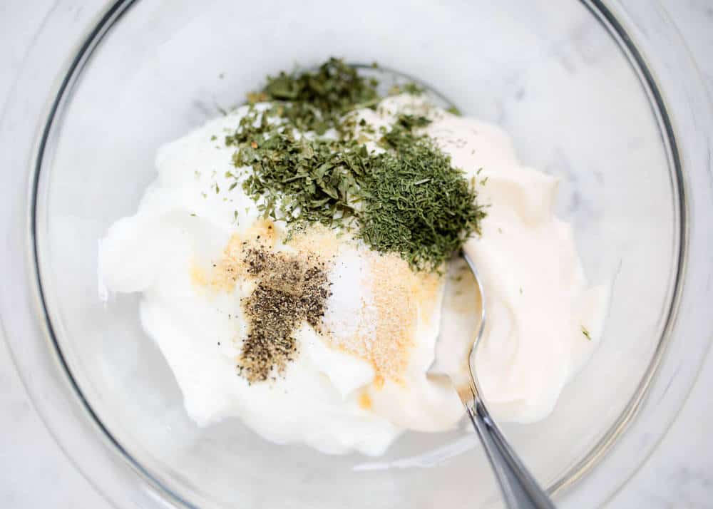 Skinny dill dip ingredients in a glass bowl. 