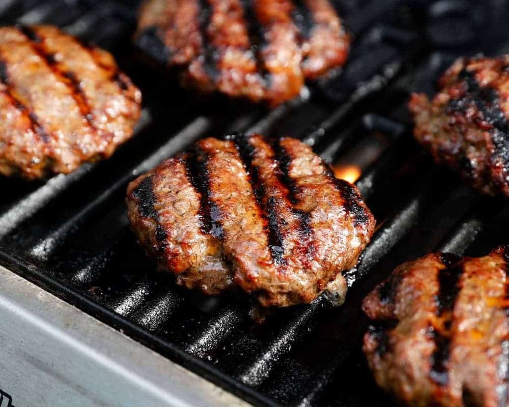 Hamburgers grilling on the grill. 