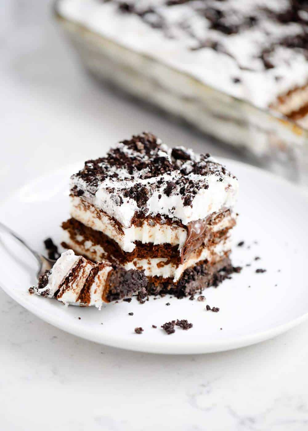 Piece of Oreo cookie ice cream cake on a white plate.