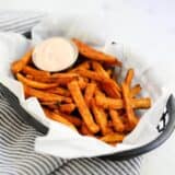 sweet potato fries in a basket with fry sauce