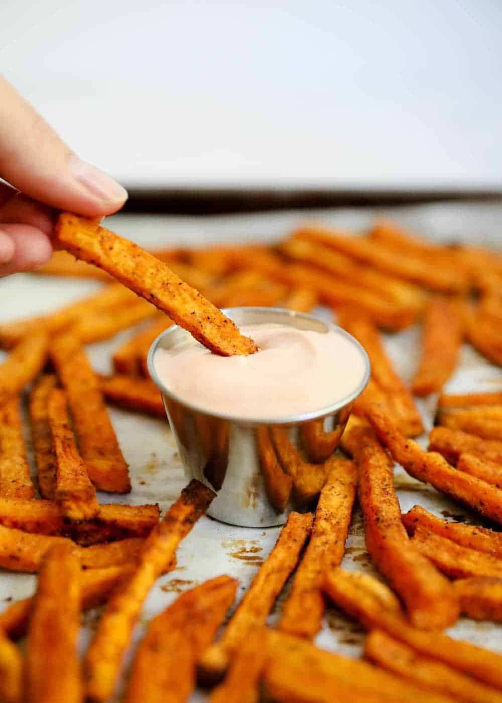 Dipping sweet potato fry into fry sauce.