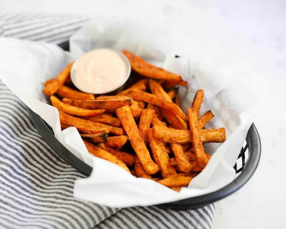 sweet potato fries in a basket with fry sauce 