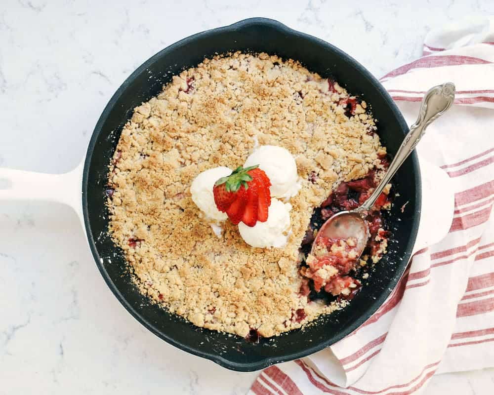 Strawberry rhubarb crisp in cast iron skillet.