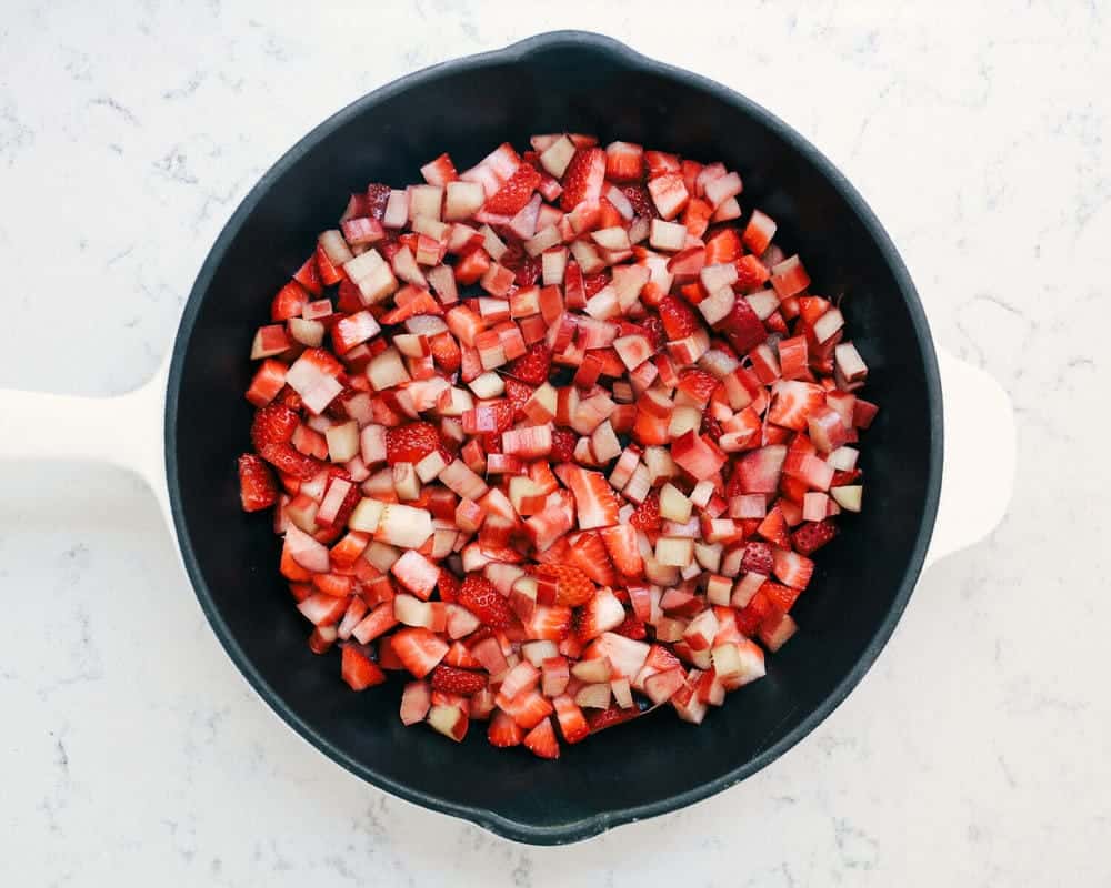 Fresh chopped strawberries and rhubarb in cast iron skillet.