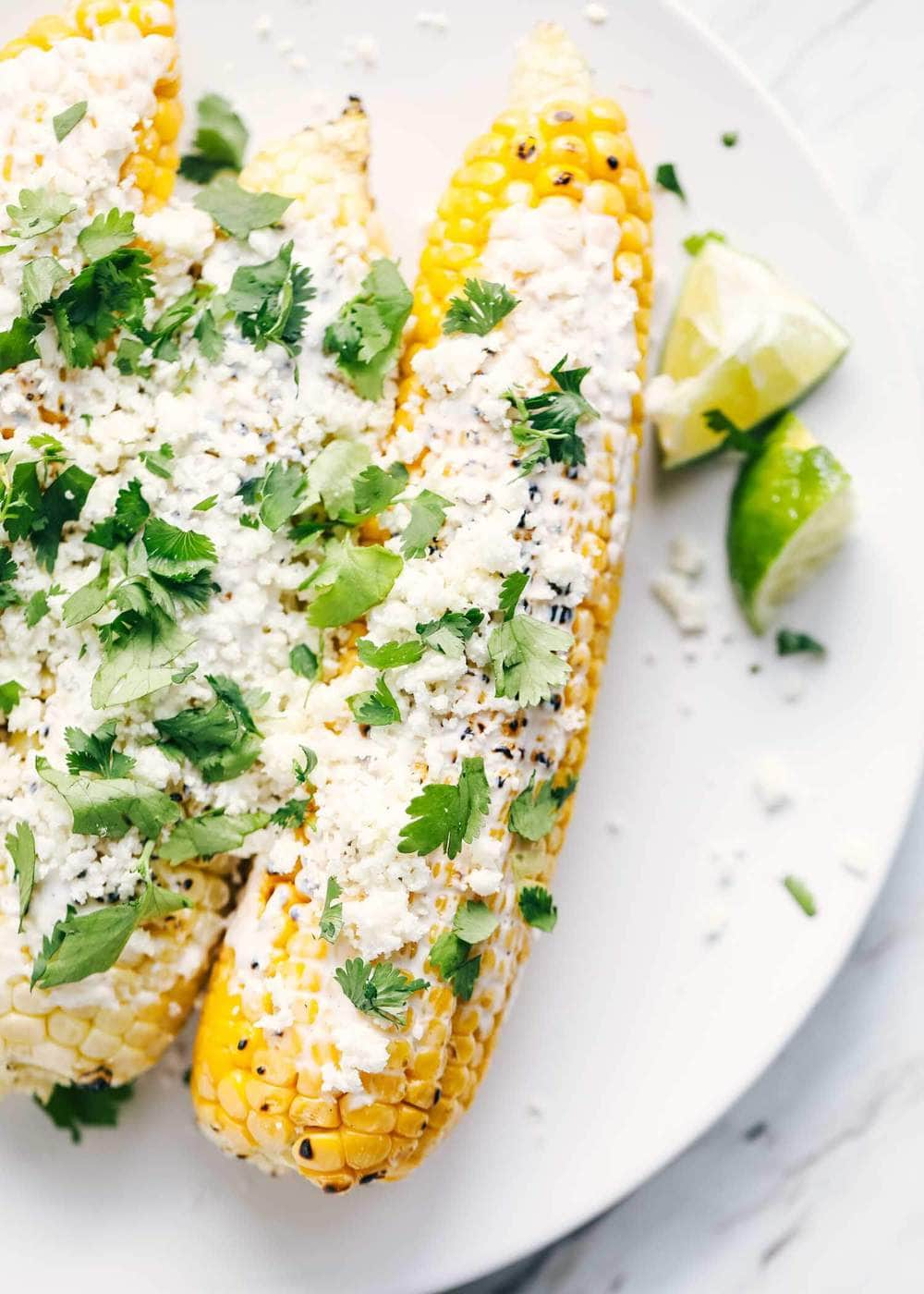 Mexican street corn on white plate.