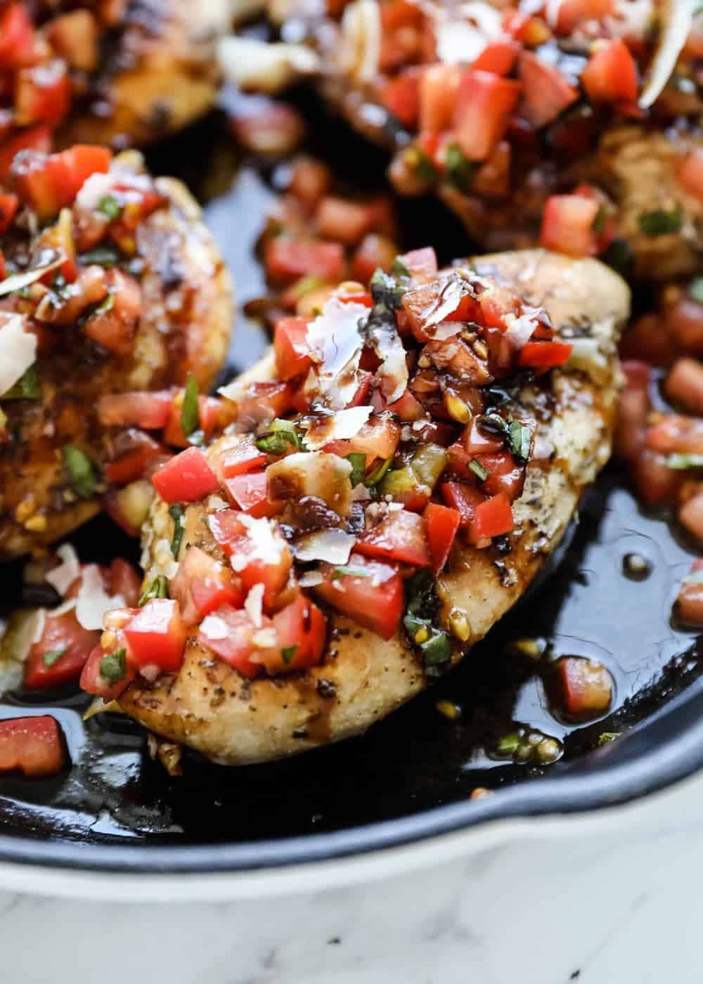 Close up of bruschetta chicken in skillet.