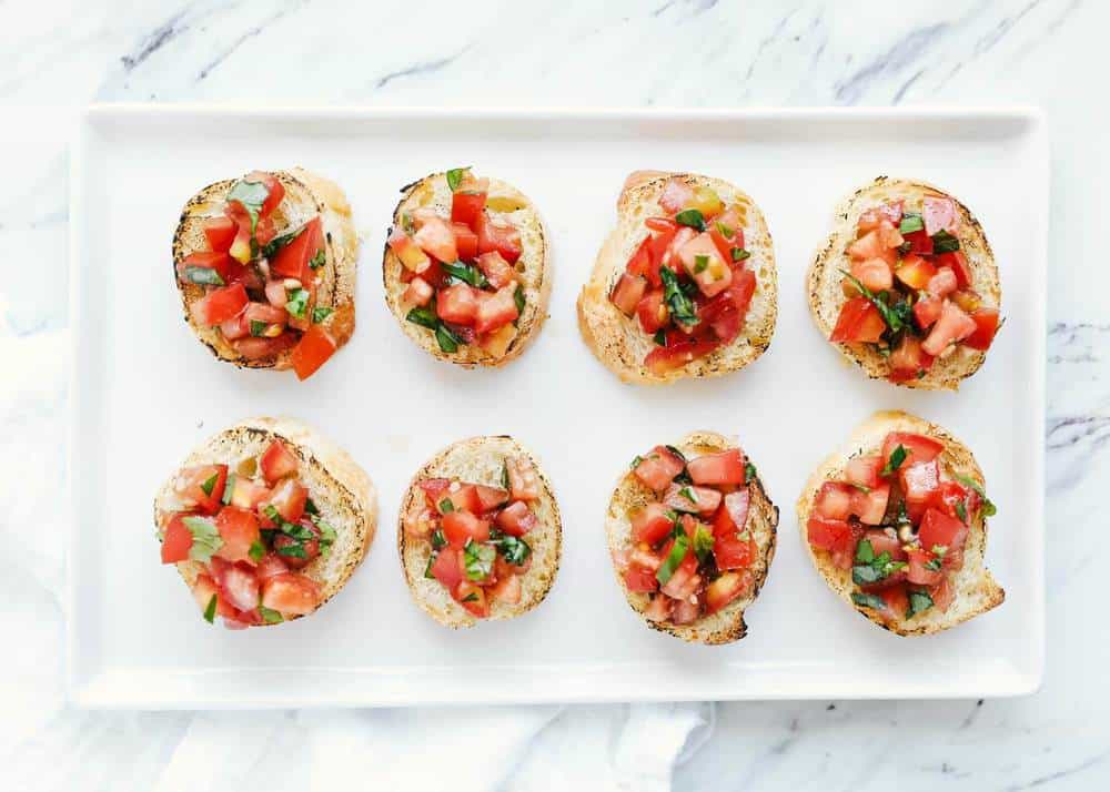 Toasted baguette slices with homemade bruschetta on top.