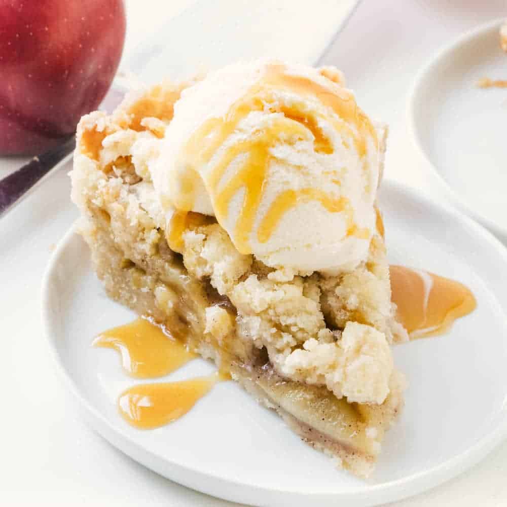 Slice of apple pie on a white plate.